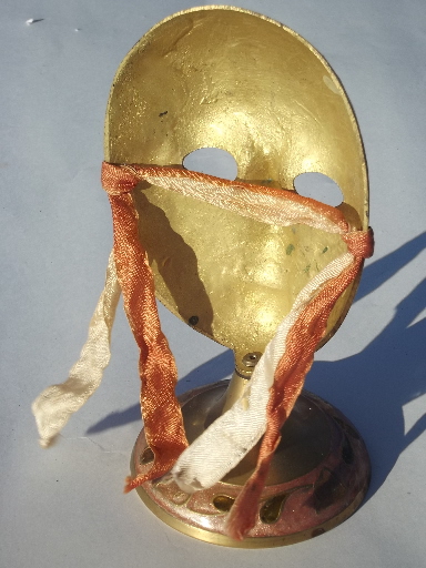 Enameled brass mask on display stand, masked face made in India