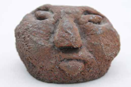 Brutalist iron head candle holder, naive art ugly face old man in the moon?
