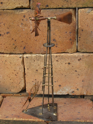 Hand-crafted metal art copper windmill built on old farm mower tooth