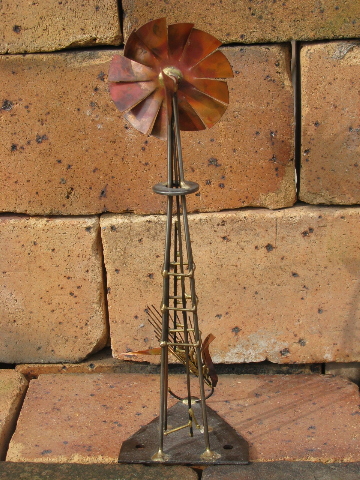 Hand-crafted metal art copper windmill built on old farm mower tooth